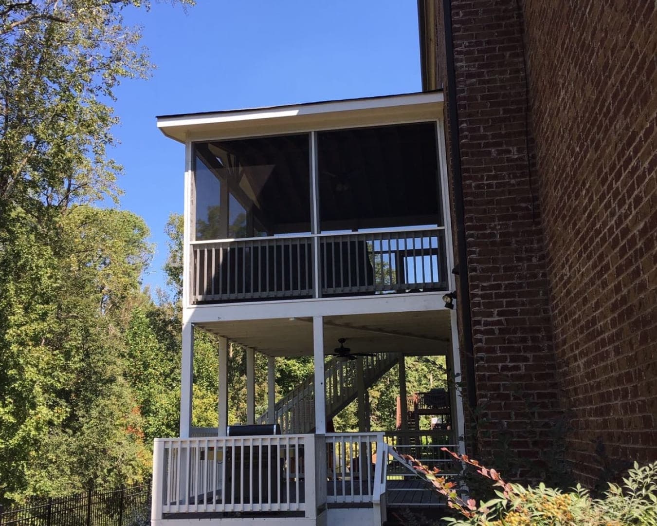 Two-storey screened porch and deck built onto a brick home